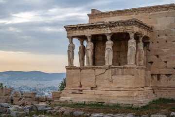 The Caryatides, female statues in the Acropolis of Athens, Greece, framed by a vibrant sunset