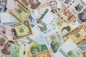 Big amount of money bills of different currencies and countries. Assortment background of international cash in big pile close up