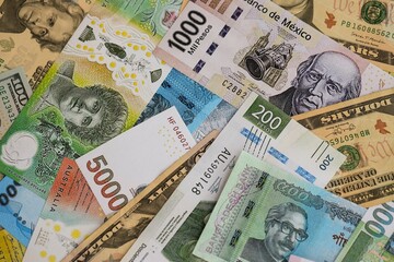 Big amount of money bills of different currencies and countries. Assortment background of international cash in big pile close up