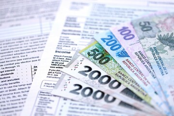 Argentine pesos money bills in big amount lies on table with pen and tax forms close up