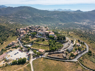 Aerial view of the medieval hilltop village of Sant’Antonino on the Mediterranean island of Corsica with the Reginu valley in the distance