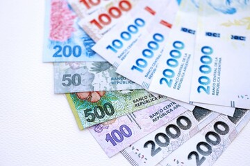 Obraz premium Argentine pesos money bills in big amount lies on white table close up