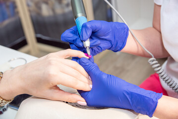 Hardware removal of gel polish in a nail salon. The process of nail care