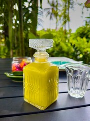 A close-up, eye-level shot with a shallow depth of field features a decorative glass decanter...