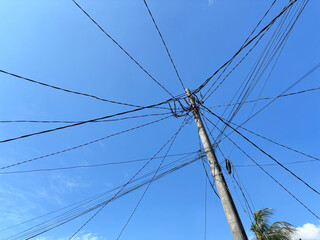 Electric Utility Pole with Multiple Wires Against Clear Blue Sky