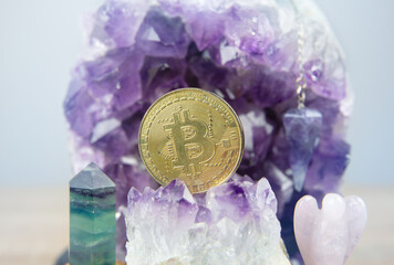 A gold Bitcoin coin resting inside an open amethyst quartz geode. Spiritual cryptocurrency and investment concept.