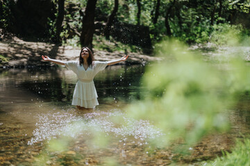A woman in white dress stands jubilantly in a tranquil forest stream surrounded by vibrant...