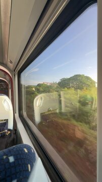 moving train with modern interior and natural green view in the background. natural view from train window seat. ets intercity train from Penang to Kuala Lumpur