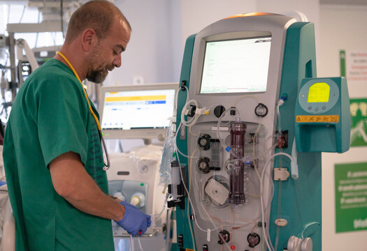 Doctor preparing dialysis machine for patient treatment in hospital room