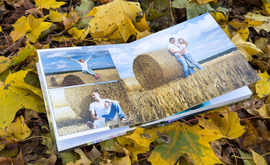 Photobook on the leaves background, closeup of photobook, family photo album