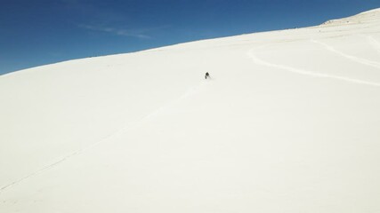 Person driving snow mobile up the mountain, extreme winter sports aerial
