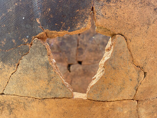 Antique clay vase with cracks. Old terracotta jug close-up, ancient background.