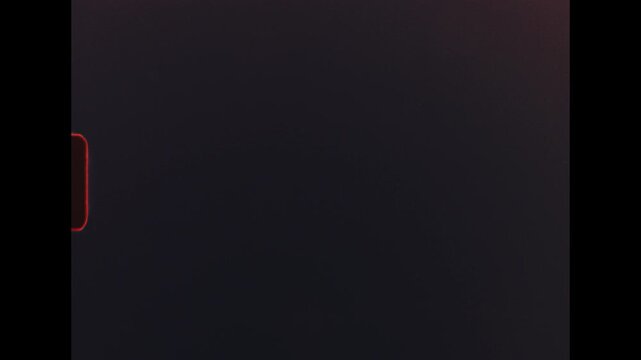 Vintage red authentic film grain, dust particles, and scratched overlay, evoking nostalgic cinematic texture against stark black background - filmed on super 8 film