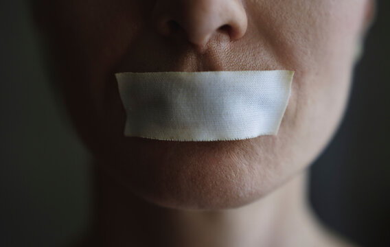 Person with adhesive tape on mouth representing censorship and silence
