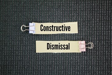 A paper with the words Constructive dismissal occurs when an employee resigns because their employer's actions have made their working conditions intolerable, essentially forcing them to quit.