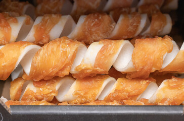 This is a close up view of a tray filled with twisted chicken sticks