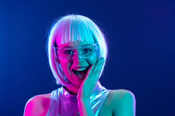 Pleasantly surprised futuristic woman in neon lights with smart glasses