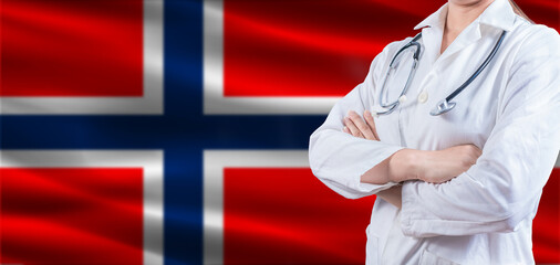 Doctor with crossed arms on Norway flag. Norway health and care concept. Female doctor on Norway flag