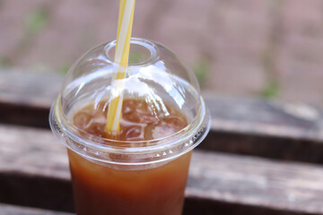 Bumble coffee. Coffee with juice in a disposable plastic cup with a straw. Coffee with orange...