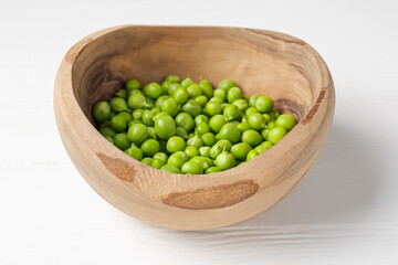 Fresh ripe green peas on white wooden table, closeup