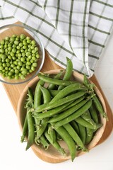 Fresh ripe green peas on white wooden table, flat lay