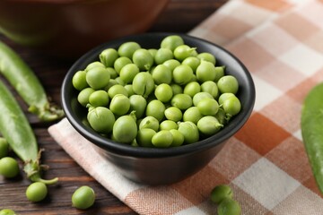 Fresh ripe green peas on wooden table, closeup