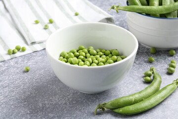 Fresh ripe green peas on grey table, closeup