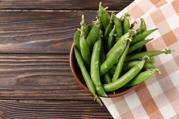 Fresh ripe green peas on wooden table, top view. Space for text