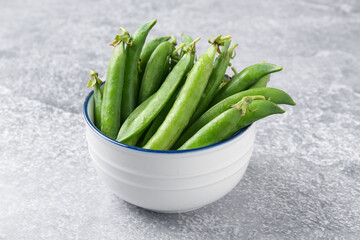 Fresh ripe green peas on grey table, closeup