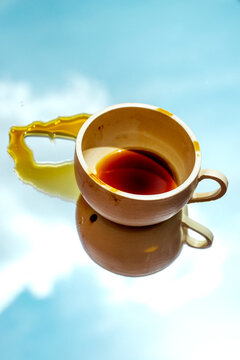 Creative reflection of a coffee cup with stains against a sky background