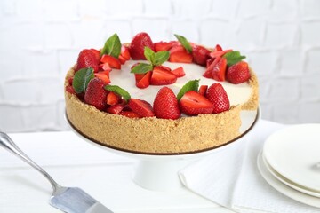 Delicious cheesecake with strawberries and mint on white wooden table, closeup