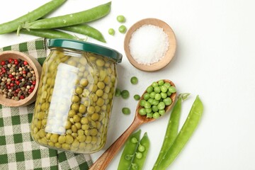 Tasty pickled peas in jar and ingredients on white table, flat lay. Space for text