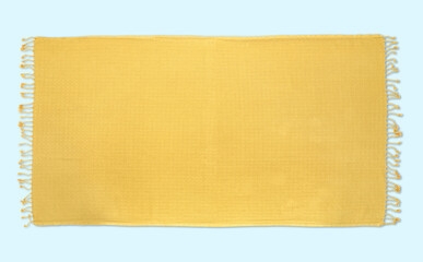 Yellow beach towel on pastel light blue background, top view