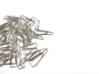Stack of Silver Paper Clips Scattered on White Background