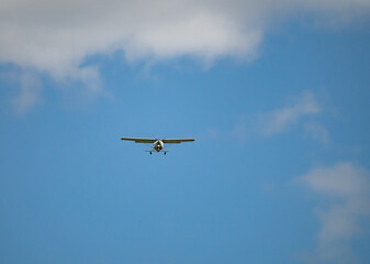 einmotoriges Flugzeug - Leichtflugzeug in der Luft vor blauem Himmel und weiße Wolken