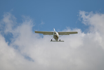 einmotoriges Flugzeug - Leichtflugzeug in der Luft vor blauem Himmel und weiße Wolken