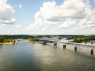 Scenic view of a bridge and lush greenery under a partly cloudy sky in Florence, Alabama.