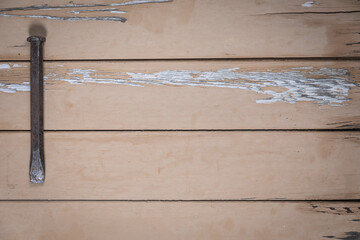Old metal chisel placed on the left edge of a rustic beige wooden table. Space is left free for...