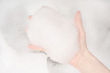 Female hands in foam close-up. girl's hands in soap foam. washing, cleaning, washing dishes