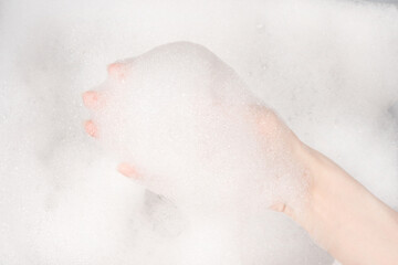 Female hands in foam close-up. girl's hands in soap foam. washing, cleaning, washing dishes