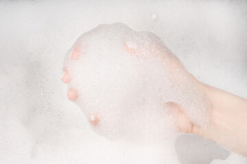 Female hands in foam close-up. girl's hands in soap foam. washing, cleaning, washing dishes
