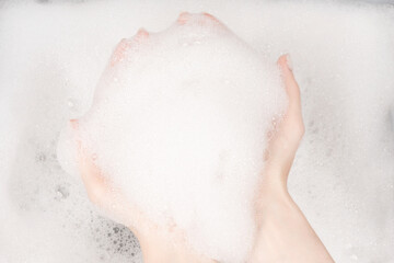 Female hands in foam close-up. girl's hands in soap foam. washing, cleaning, washing dishes