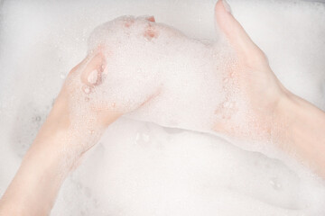 Female hands in foam close-up. girl's hands in soap foam. washing, cleaning, washing dishes
