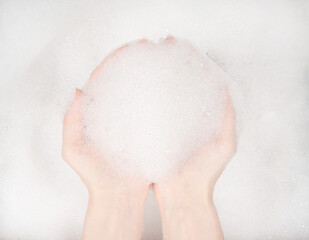 Female hands in foam close-up. girl's hands in soap foam. washing, cleaning, washing dishes