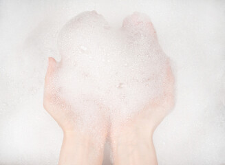 Fototapeta premium Female hands in foam close-up. girl's hands in soap foam. washing, cleaning, washing dishes