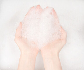 Female hands in foam close-up. girl's hands in soap foam. washing, cleaning, washing dishes