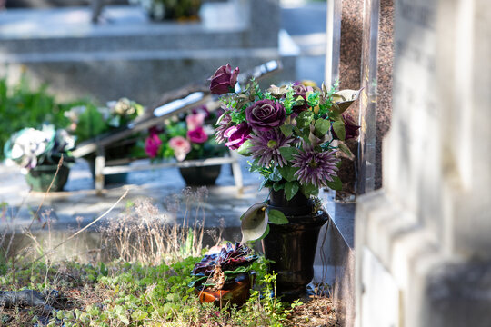 Vue de tombes fleuries et d&eacute;cor&eacute;es dans un cimeti&egrave;re de ville. Cela permet de rendre hommage au d&eacute;funt et de t&eacute;moigner son attachement et le respect envers cet &ecirc;tre cher.