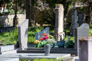 Vue de tombes fleuries et décorées dans un cimetière de ville. Cela permet de rendre hommage au défunt et de témoigner son attachement et le respect envers cet être cher.