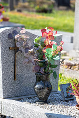 Le fleurissement d’une tombe avec un bouquet de fleurs rouge. Cela permet de rendre hommage au défunt et de témoigner son attachement et le respect envers cet être cher.