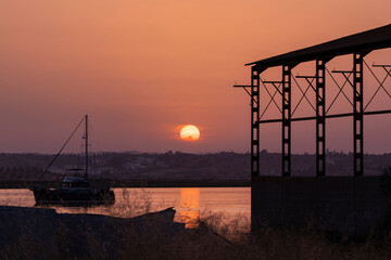 Atardecer con el sol grande en el rio Guadalquivir